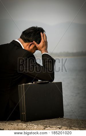 Young businessman is sitting in dismay with his business.