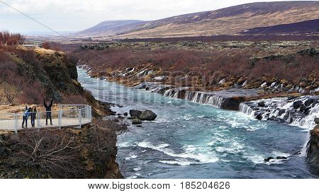 Happy Asian Family Tourists At Hraunfossar Waterfall In Iceland