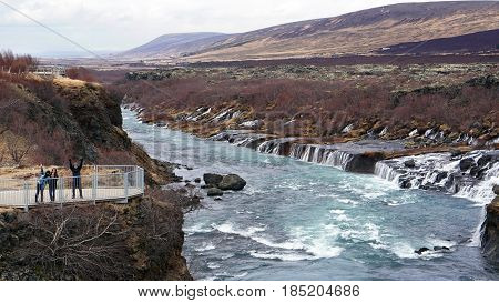 Happy Asian Family Travelers At Hraunfossar Waterfall In Iceland