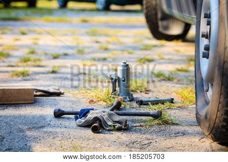Manual socket wheel wrench and jack lying on ground. Tire car repair objects concept.