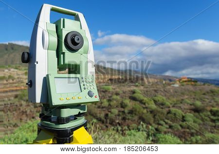 Modern surveyor equipment theodolite or tacheometer used in surveying and building construction for precise measurement. Total station outdoor at construction site. Copy space.