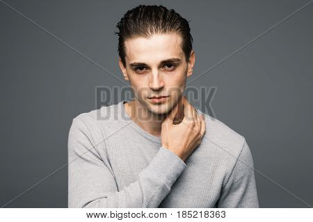 Portrait Of A Smart Serious Handsome Young Man Standing Against Grey Background