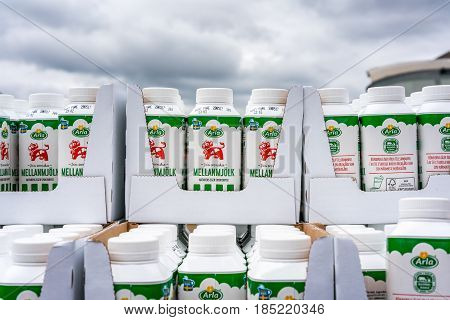 Milk cartons stacked outdoors. 
Vallentuna, Sweden - May 06, 2017: Close up of many green milk cartons stacked in rows outdoors from Swedish milk manufacturer Arla, Labeled with their red cow logo.