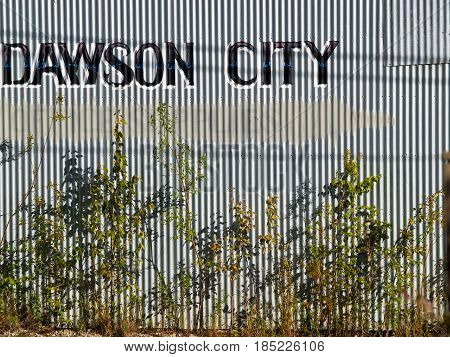 Dawson City, Canada -August  4, 2008; Dawson City sign hand painted on corrugated iron wall