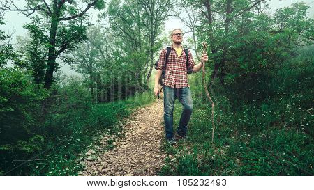 Man traveler walks along a path through a mountain forest. Travel lifestyle. North Caucasus Russia