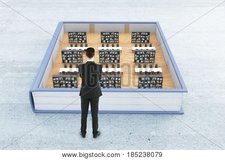 Thougtful businessman looking at abstract library inside book. Concrete background. Knowledge concept. 3D Rendering