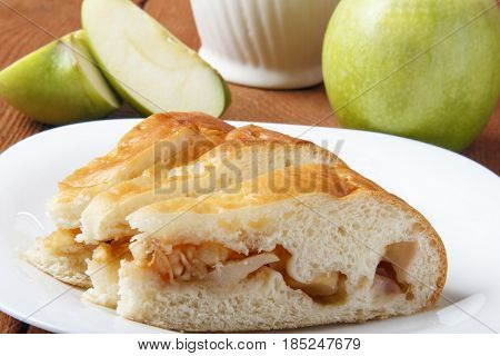 Homemade apple cake and green apple over natural wood background