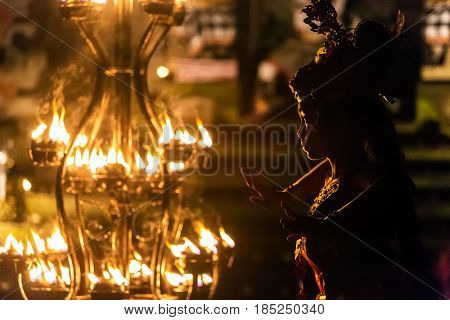 Ubud, Indonesia - August 8, 2016: Beautiful balinese woman dances during a traditional Kecak Fire Dance ceremony in Hindu temple.