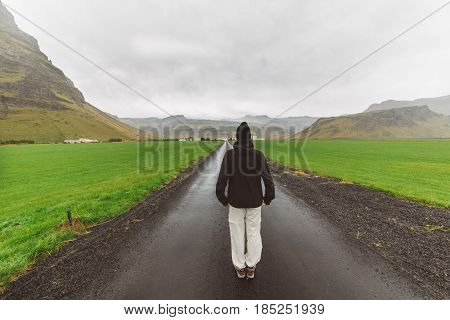 Camping tourist woman hiker cheering near big active volcano in south of Iceland, Eyafjallajokull.Camper adventurer visiting Iceland and touring through ring road.