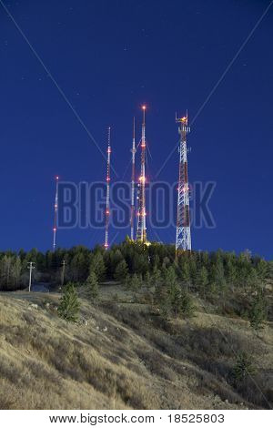 radio towers on mountain against night sky