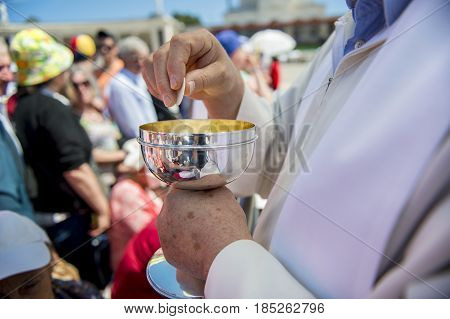 Fatima Portugal - May 13 2014: Priest holding a ciborium with sacramental bread at the Sanctuary of Fatima during the celebrations of the apparition of the Virgin Mary in Fatima Portugal.
