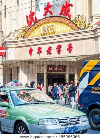 Shanghai, China - Nov 4, 2016: Along Nanjing Road Pedestrian Street - Shen Dacheng Restaurant (Chinese characters) occupies a historic building. Crowds of people and cab at front.