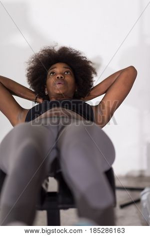young fit african american woman doing sit ups in fitness studio at the gym.Abdominal exercises Sit up