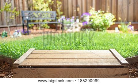 Empty wooden crate with blurred backyard on background. Display of products.