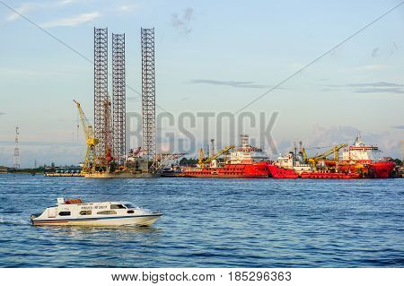 Labuan,Malaysia-May 7,2016:View of speed boat passengers with background of offshore oil & gas support vessels & Jackup Rig in Labuan island,Malaysia on 7th May 2016