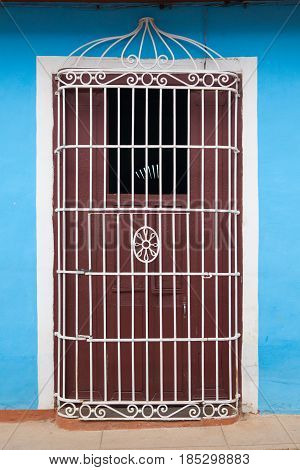 Typical colonial building with door iron grate in Trinidad Cuba