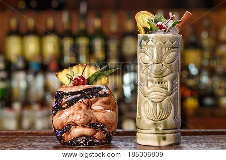 Selected summer alcoholic cocktails on the bar. Cocktails in tiki glasses based on rum coconut cream fruit juices with vanilla. Space for text