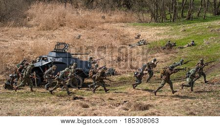 Gatchina Russia - May 7 2017: Historical reconstruction of the battles of World War II. Attack of the German soldiers. In combat an armored personnel carrier is used.
