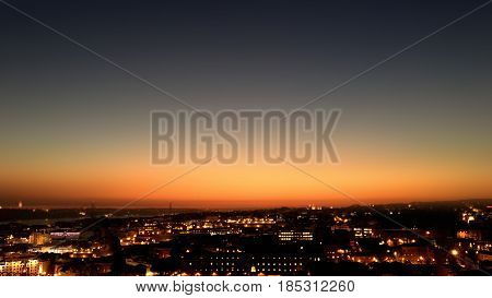 City night from the view point on top of hill at beautiful sunset. Bird view over the city at night with abstract urban night lights in Lisbon Portugal