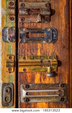 Many variuos sliding bolts on wooden door