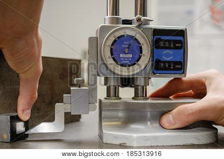 Person with accurate metalwork with a height measuring device - close up