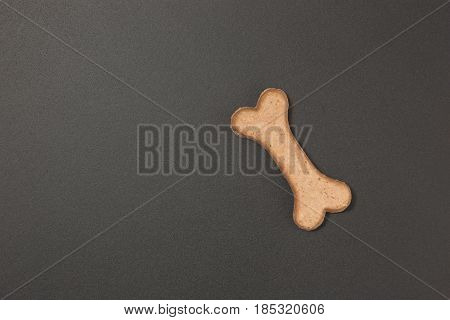 Dog biscuit on black background to connote a concept of feeding animals