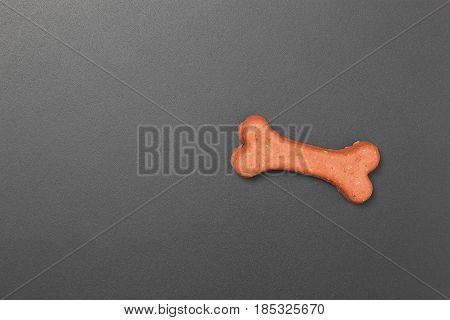 Dog biscuit on black background to connote a concept of feeding animals