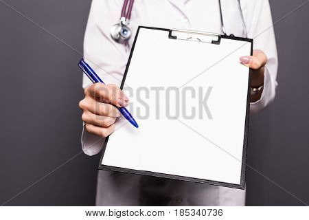 Smiling Doctor Woman With Documents And Pen For Your Signature Isolated On Grey