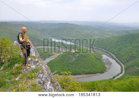 Hiker on top of a mountain enjoy the beautiful view of nature, forest and river in valley. View on meanders of Morava river  from Kablar, Serbia