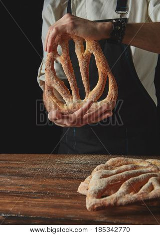 Baker's hands hold fougas bread