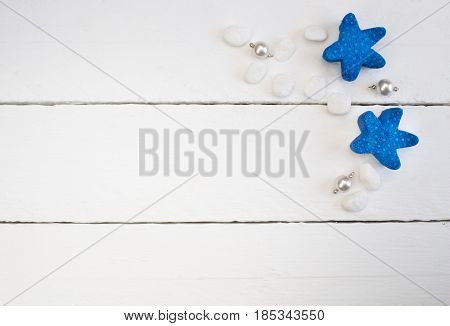 Background with white pearl necklace pendants beach pebbles and blue starfish on white wooden planks - concept of relaxation and luxury