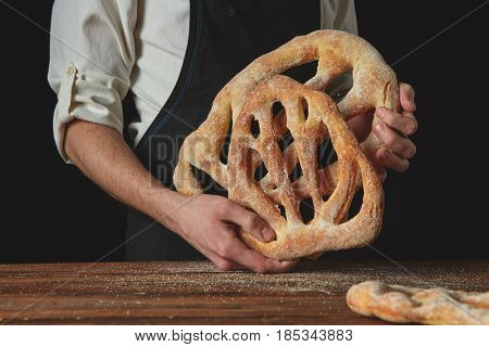 Baker is holding fougas bread