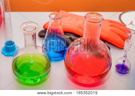Laboratory expreriment with test-tubes with colored chemical reagents, retorts and flasks