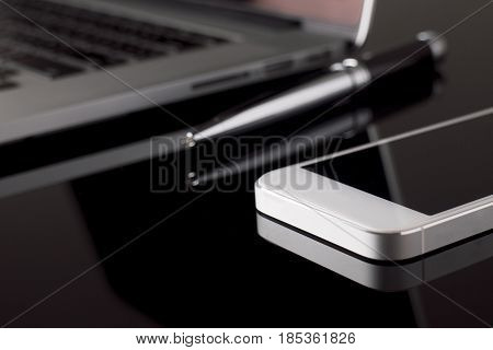 Close up Smartphone on table with laptop blur background. Technology and Business Concept