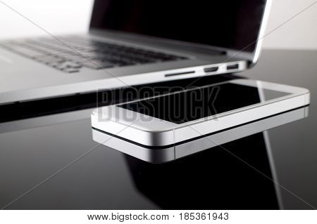 Close up Smartphone on table with laptop blur background. Technology and Business Concept