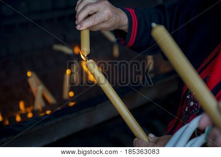 Fatima Portugal - May 13 2014: Woman lighting a candle to pay a promise at the Sanctuary of Fatima during the celebrations of the apparition of the Virgin Mary in Fatima Portugal.