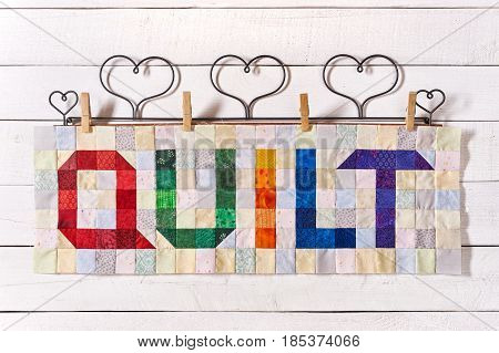 The word quilt sewn from colorful square and triangle pieces of fabric