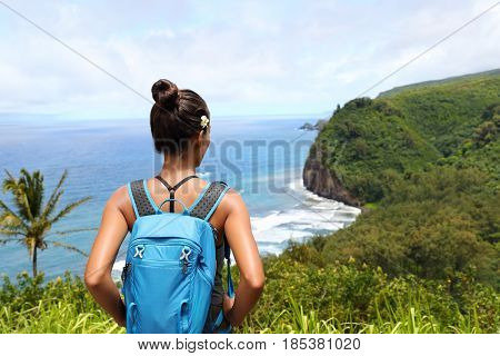 Hawaii travel nature hiker girl hiking in Pololu valley enjoying lookout view of mountains. Big island destination, woman tourist in Hawaii, USA.