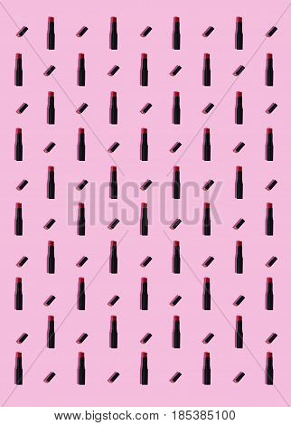 Red lipsticks pattern on a pink background.