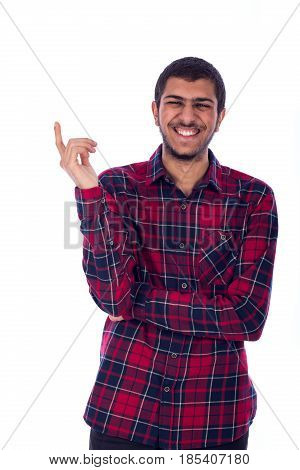 Happy friendly young mansmiling and pointing up guy wearing red shirt isolated on white background