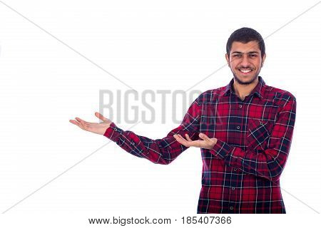 Happy friendly young man standing confidently and showing something guy wearing red caro shirt isolated on white background