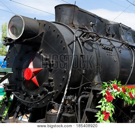 SARATOV RUSSIA - MAY 6 2017: Victory Train. The mobile museum of the Great Patriotic War. Old steam locomotive decorated with flowers. Close-up.