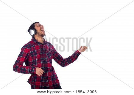 Super excited happy friendly young man listening to music guy wearing red caro shirt and headphones isolated on white background