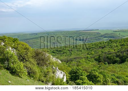 View of the hilly landscape of Palava with forests rocks in South Moravia under a blue sky with clouds