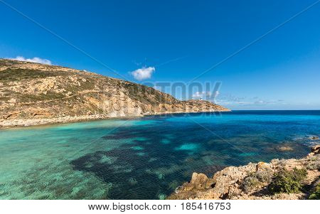 Lighthouse and turquoise Mediterranean sea at Revellata near Calvi in the Balagne region of Corsica with blue sky and rocky coastline
