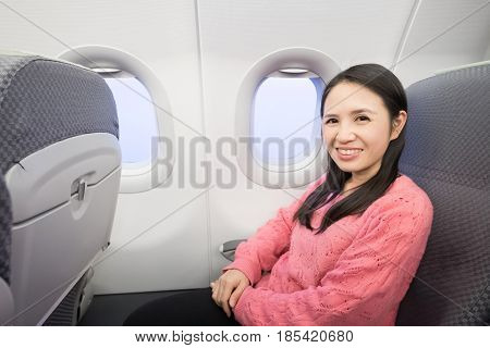 Middle aged woman smie happily in the airplane