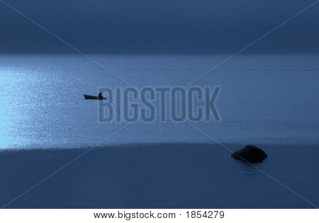 Natten, båt med fiskaren i havet