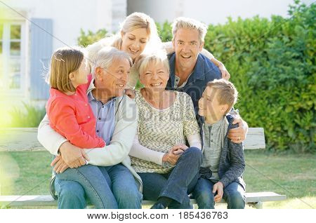 Portrait of intergenerational family sitting on bench