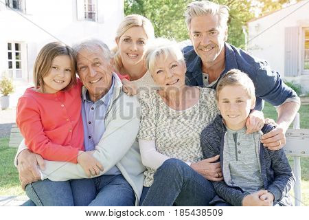 Portrait of intergenerational family sitting on bench