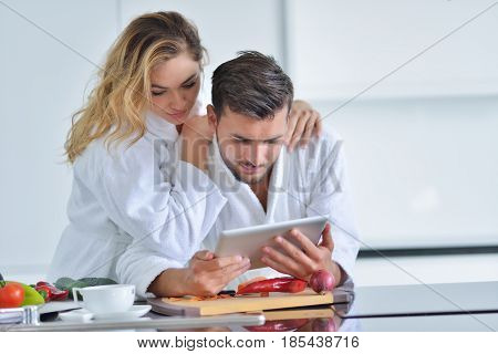 Happy couple cooking breakfast together in the kitchen.